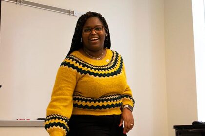 female, African American student wearing yellow and black sweater